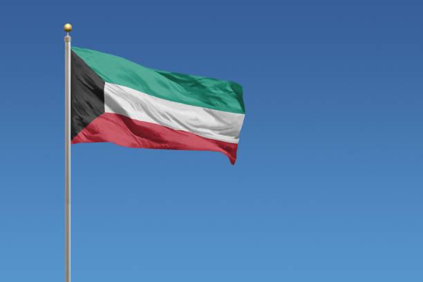 Flag of Kuwait in front of a clear blue sky