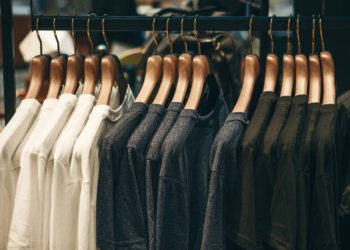 Different or choice of t-shirts on hangers hang in a row.
